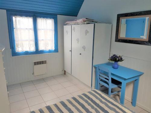 een slaapkamer met een blauwe tafel en een koelkast bij Petite maison de plain-pied à 150m de la mer à TREGASTEL - Réf 78 in Trégastel