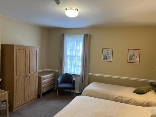 1 dormitorio con 2 camas, ventana y silla en Royal Oak Hotel, Garstang, en Garstang