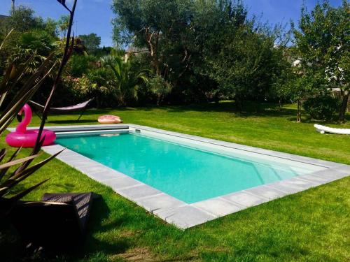 une piscine dans l'herbe avec un flamingo rose à côté de celle-ci dans l'établissement Superbe maison 4 étoiles pour 8 pers avec piscine sur le port de PERROS-GUIREC - Réf 873, à Perros-Guirec