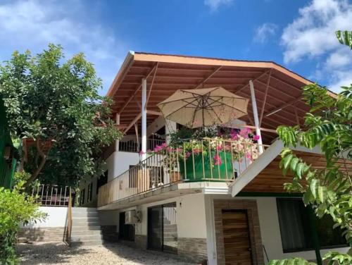 a house with a balcony with an umbrella at 6 Cute studio, GREAT location, close to beach! With AC! in Carrillo