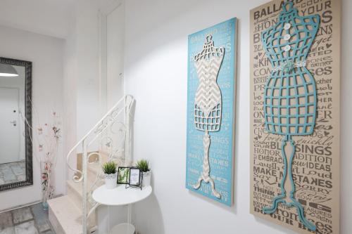 a hallway with two paintings of a dress on the wall at Apartments Blue Ivy in Zadar