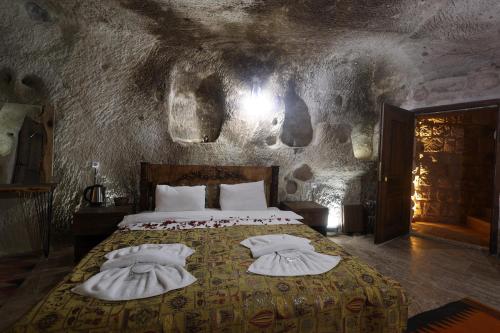 a bedroom with a bed with towels on it at Cappadocia Snora Cave in Nevşehir