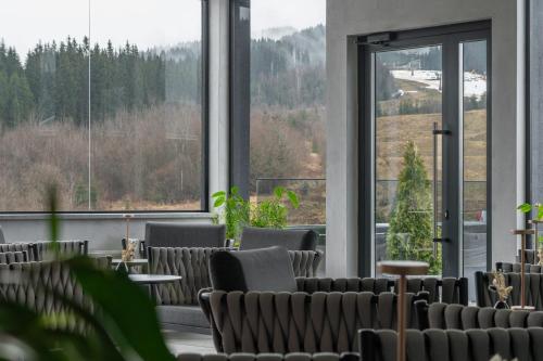 a room with chairs and a large window at SAVOIE Apartments Bukovel in Bukovel