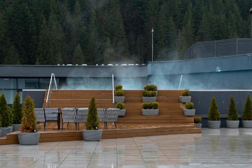 a seating area with a table and chairs in front of a building at SAVOIE Apartments Bukovel in Bukovel