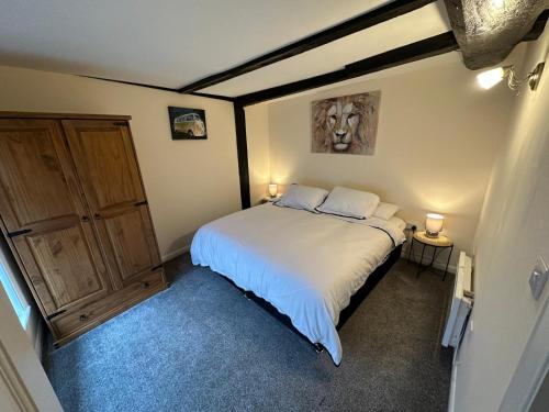 a bedroom with a bed and a wooden cabinet at Comfort in Colchester