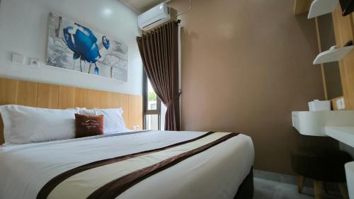 - une chambre avec un grand lit et une fenêtre dans l'établissement Premier Homestay Syariah, à Kalasan