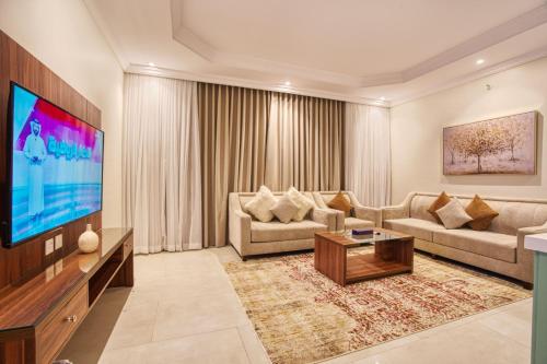 un soggiorno con un divano e una televisione di Quiet Dreams - Serviced Apartments Al-Nour Branch a Gedda