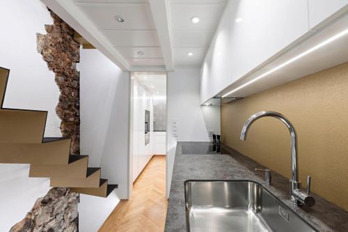 uma cozinha com um lavatório e uma parede de pedra em Boutique City Design Bijou - an bester Lage em Thun