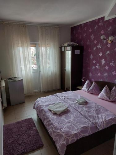 ein Schlafzimmer mit einem lila Bett mit zwei Handtüchern darauf in der Unterkunft Vila Alexandru in Eforie Nord