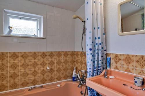 a bathroom with an orange tub and a sink at Finest Retreats - Lewcott in Sennen