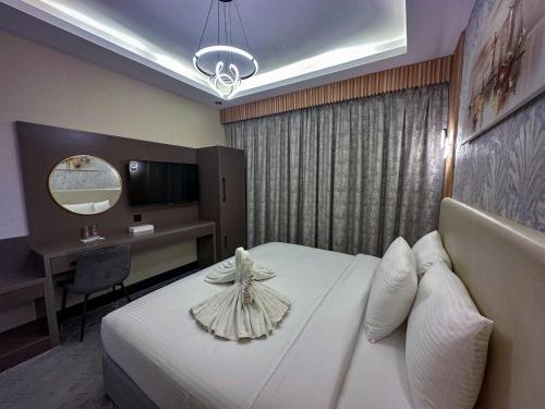 杜拜的住宿－GOLD SKY AVENUE HOTEL，配有一张床和一张书桌的酒店客房