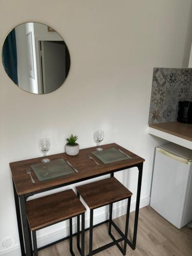 - une table avec 2 verres à vin et un miroir dans l'établissement Beau studio rénové - centre-ville/université, au Havre
