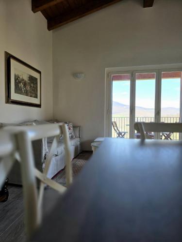 a room with a bed and a table and windows at Oasi di pace nella Val di Taro in Compiano
