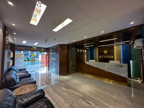 a lobby with leather couches and a stage in the background at GOLD SKY AVENUE HOTEL in Dubai