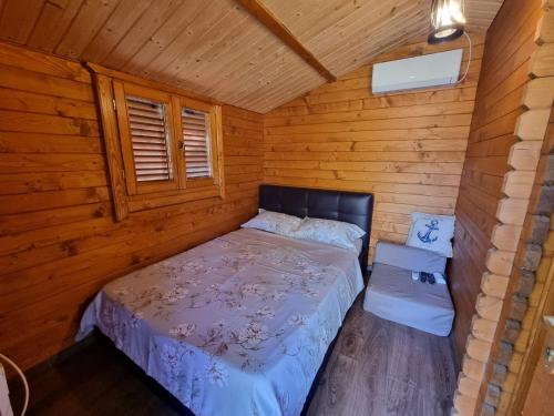 UzlinaにあるCasuta Anastasiaの木造キャビン内のベッド1台が備わるベッドルーム1室を利用します。