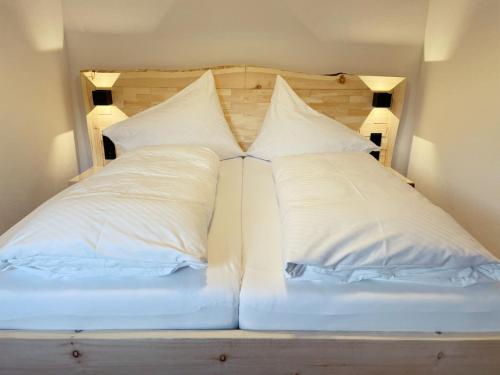 a bed with two pillows on top of it at Gästehaus Holl in Schattwald