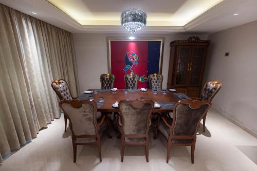 a dining room table with chairs and a painting on the wall at Novotel Hyderabad Airport in Hyderabad