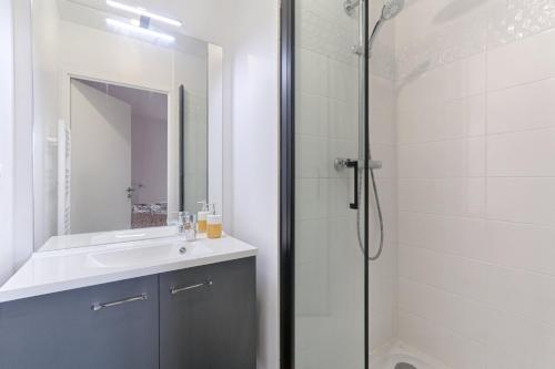 uma casa de banho com um chuveiro e um lavatório. em Résidor - Sublime Bright Apartment em Asnières-sur-Seine
