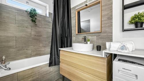 a bathroom with a sink and a bath tub at Homey Savignat Aux portes de Paris in Créteil