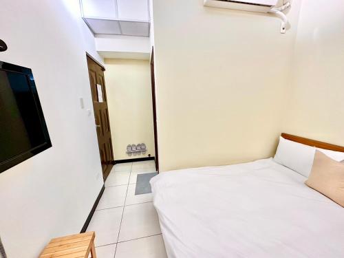 a small bedroom with a bed and a television at 莫蘭狄 in Taichung