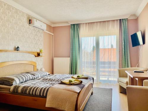 a hotel room with a bed and a window at Villa Lux in Hévíz