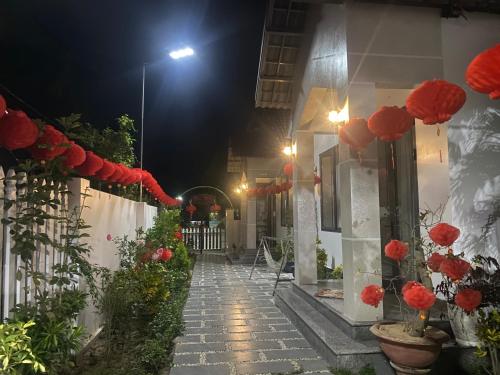 chodnik z czerwonymi kwiatami na budynku w nocy w obiekcie Bốn Mùa homestay w mieście Phu Yen
