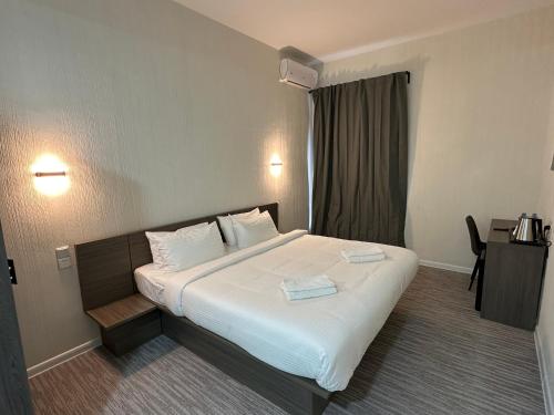 a hotel room with a bed with two towels on it at City Centre Hotel in Tashkent