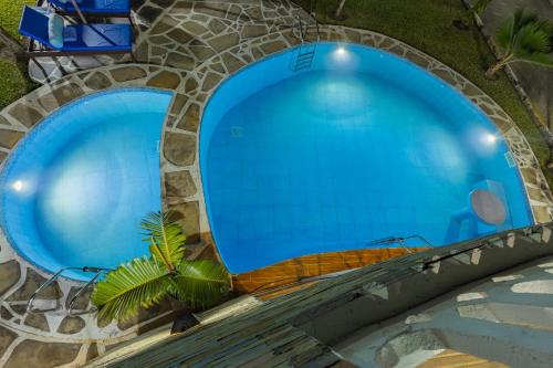 uitzicht op twee grote blauwe zwembaden bij Waiti homes in Diani Beach