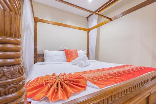 a bedroom with a bed with an orange dress on it at Waiti homes in Diani Beach