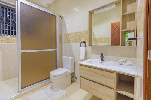 ein Bad mit einem WC, einem Waschbecken und einer Dusche in der Unterkunft Waiti homes in Diani Beach