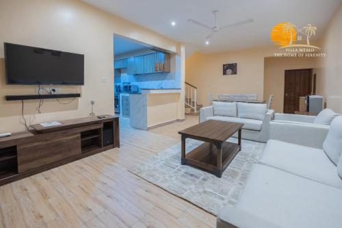 ein Wohnzimmer mit einem Sofa und einem Tisch in der Unterkunft Waiti homes in Diani Beach