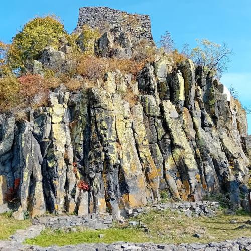 a rocky mountain with a building on top of it at Tilia Ház in Salgótarján