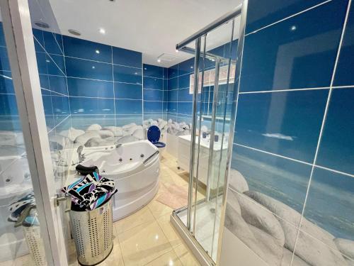 Habitación con paredes azules y baño con bañera. en Casa Zen Caleta de Fuste, en Caleta de Fuste