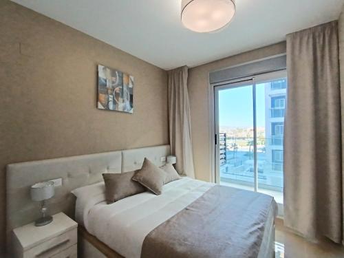 1 dormitorio con cama y ventana grande en AyF MODERNO Y LUJOSO EN 1ª LÍNEA DE PLAYA, en Oropesa del Mar