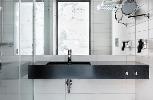 baño con lavabo negro y espejo en Comfort Hotel Winn, en Umeå
