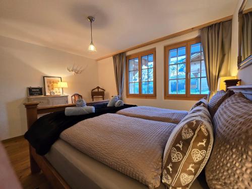 a bedroom with a bed with blue sheets and windows at Mountain Lodge *Nature *Queen Beds *Free parking in Oberwil
