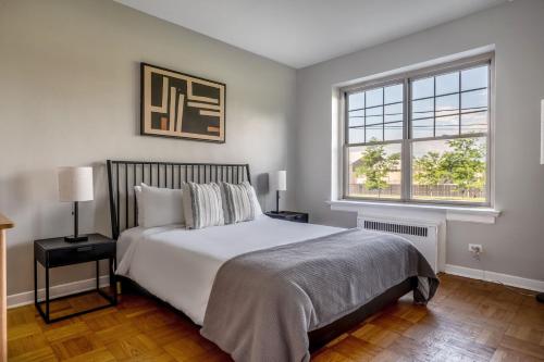 a bedroom with a large bed and two windows at Evanston 1br w courtyard nr beach university CHI-952 in Evanston