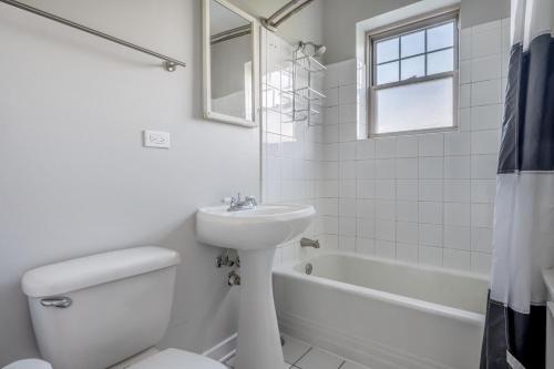La salle de bains blanche est pourvue de toilettes et d'un lavabo. dans l'établissement Evanston 1br w courtyard nr beach university CHI-952, à Evanston