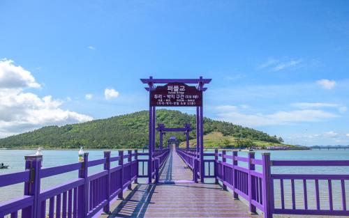 a purple pier with a sign on the water at Eldorado Resort in Sinan