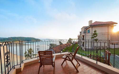 a balcony with two chairs and a view of the water at Eldorado Resort in Sinan
