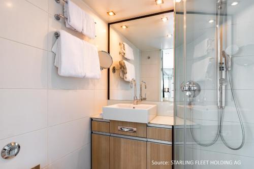a bathroom with a sink and a shower at KD Moment Premium Hotelship Köln in Cologne