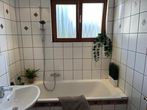 ein Badezimmer mit einer Badewanne und einem Waschbecken in der Unterkunft Fewo Weinland in Zweibrücken