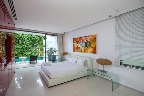 Schlafzimmer mit einem Bett und einem Glastisch in der Unterkunft Private 3-Storey Pool Villa Atika 10, for 7, views of Patong Bay in Patong Beach