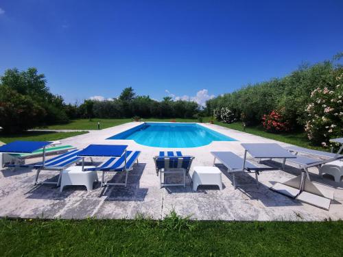 a group of lounge chairs and a swimming pool at Casa Ghirlanda appartamenti in Lazise