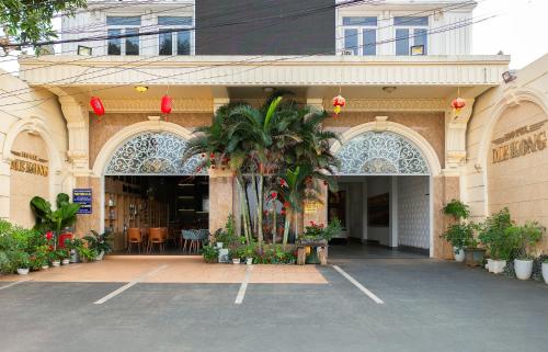 un edificio con una palma di fronte di Mekong Gia Lai Hotel - Me Kong Pleiku a Pleiku