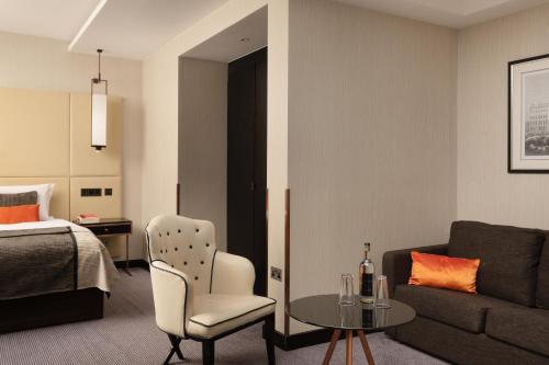 a room with a bed and a couch and a table at Montcalm Royal London House, London City in London