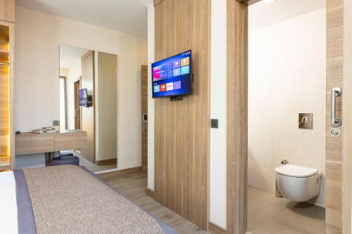 a hotel room with a bed and a flat screen tv at Ema Houses in Antalya
