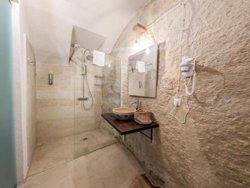 a bathroom with a walk in shower and a sink at Case al Borgo - Albergo diffuso in Agira