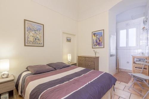 a bedroom with a bed and a desk and a window at Le Napoléon - Appt à moins dun km de la plage in LʼÎle-Rousse