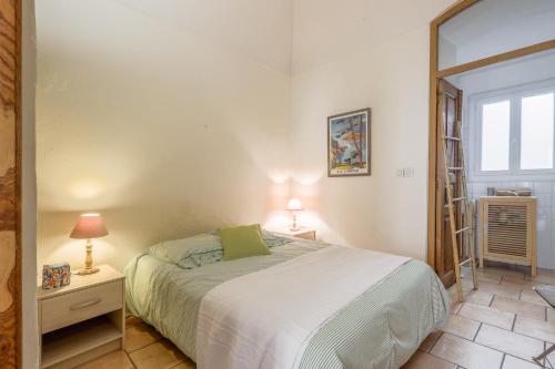 a bedroom with a bed and a window at Le Napoléon - Appt à moins dun km de la plage in LʼÎle-Rousse